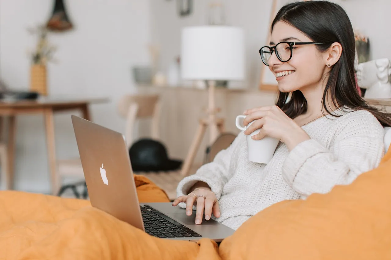 femeie cu zambet larg la laptop
